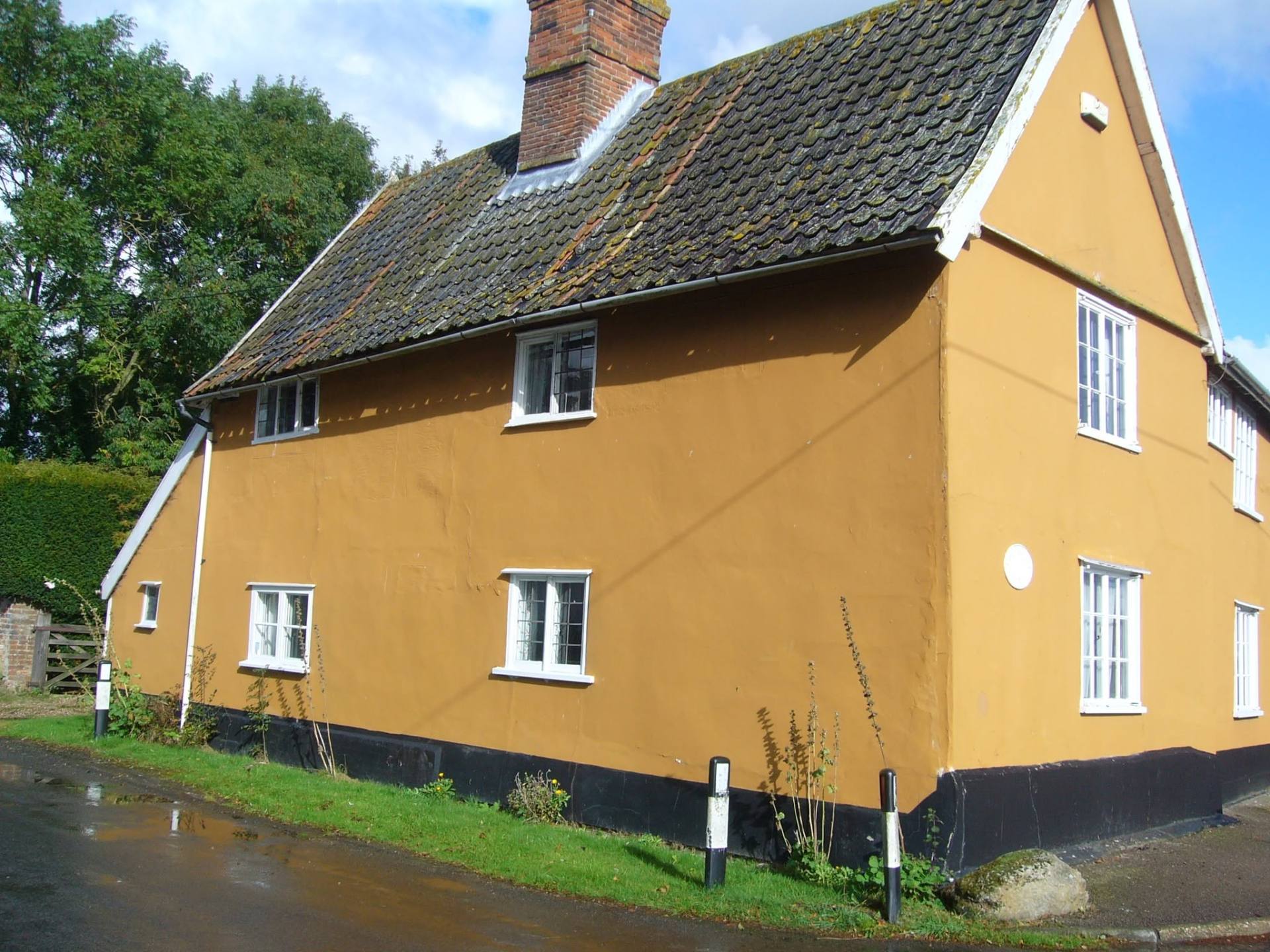Historic house exterior covered in flat orange impermeable render