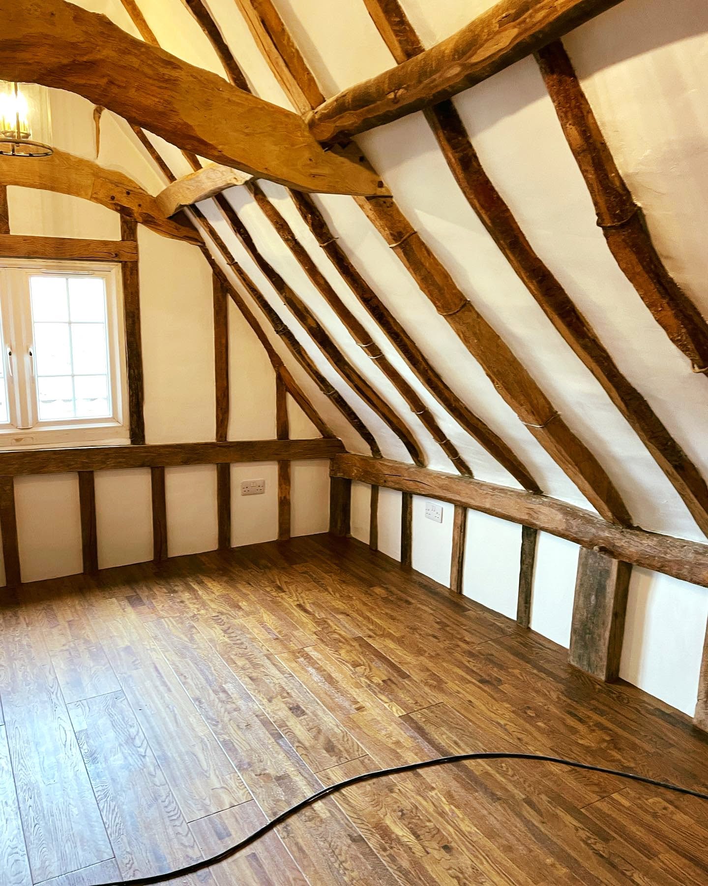Cosy cottage living room with exposed beams and white FineLime plaster walls