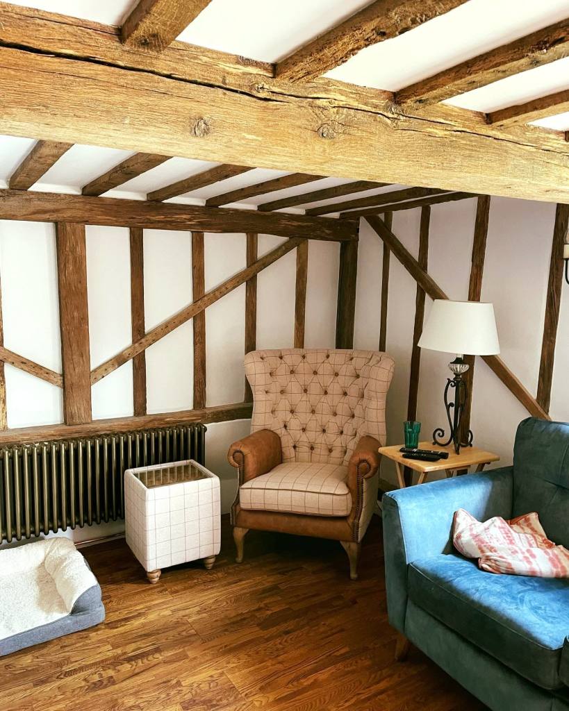 Cosy cottage living room with exposed beams and white FineLime plaster walls