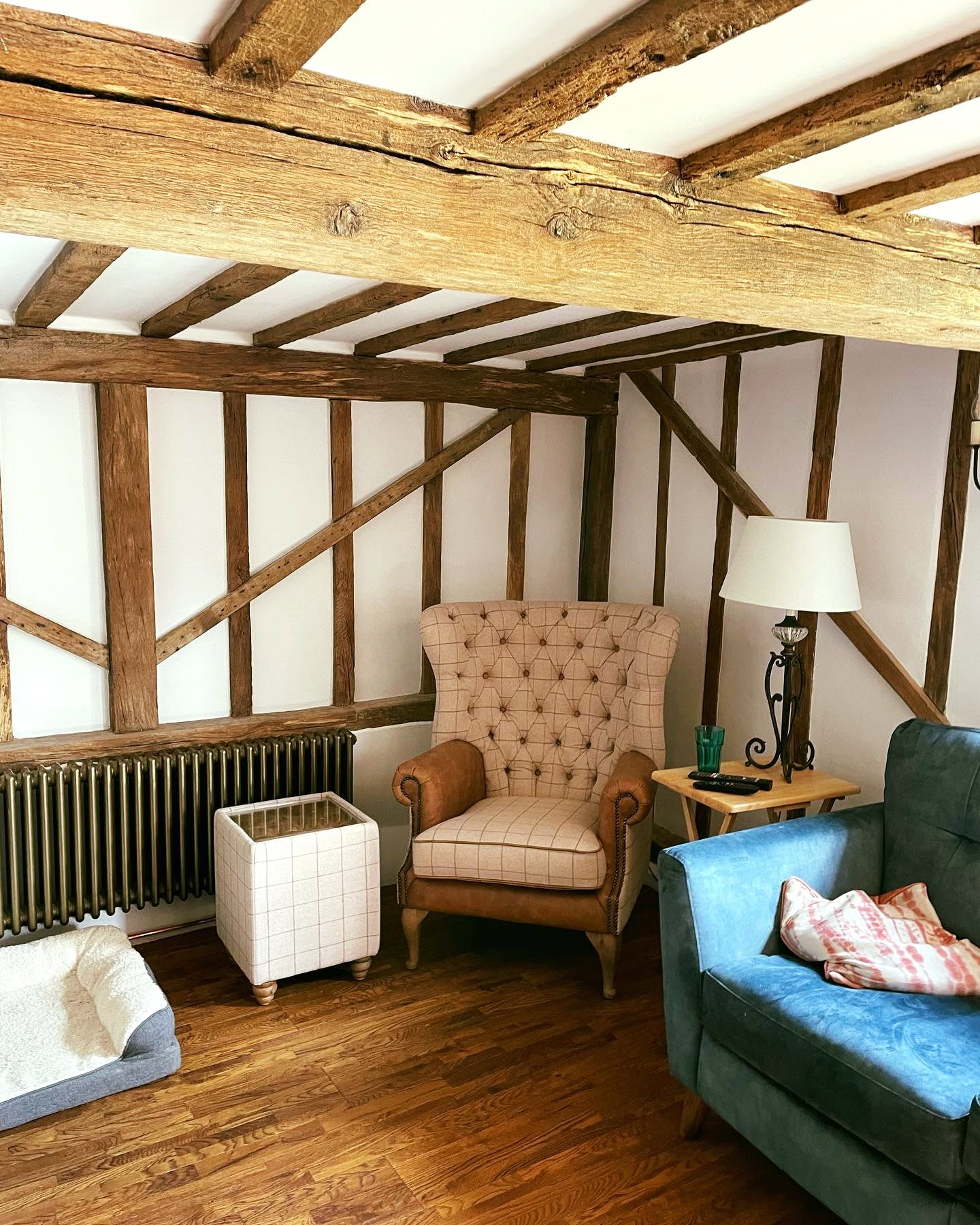 Cosy cottage living room with exposed beams and white FineLime plaster walls