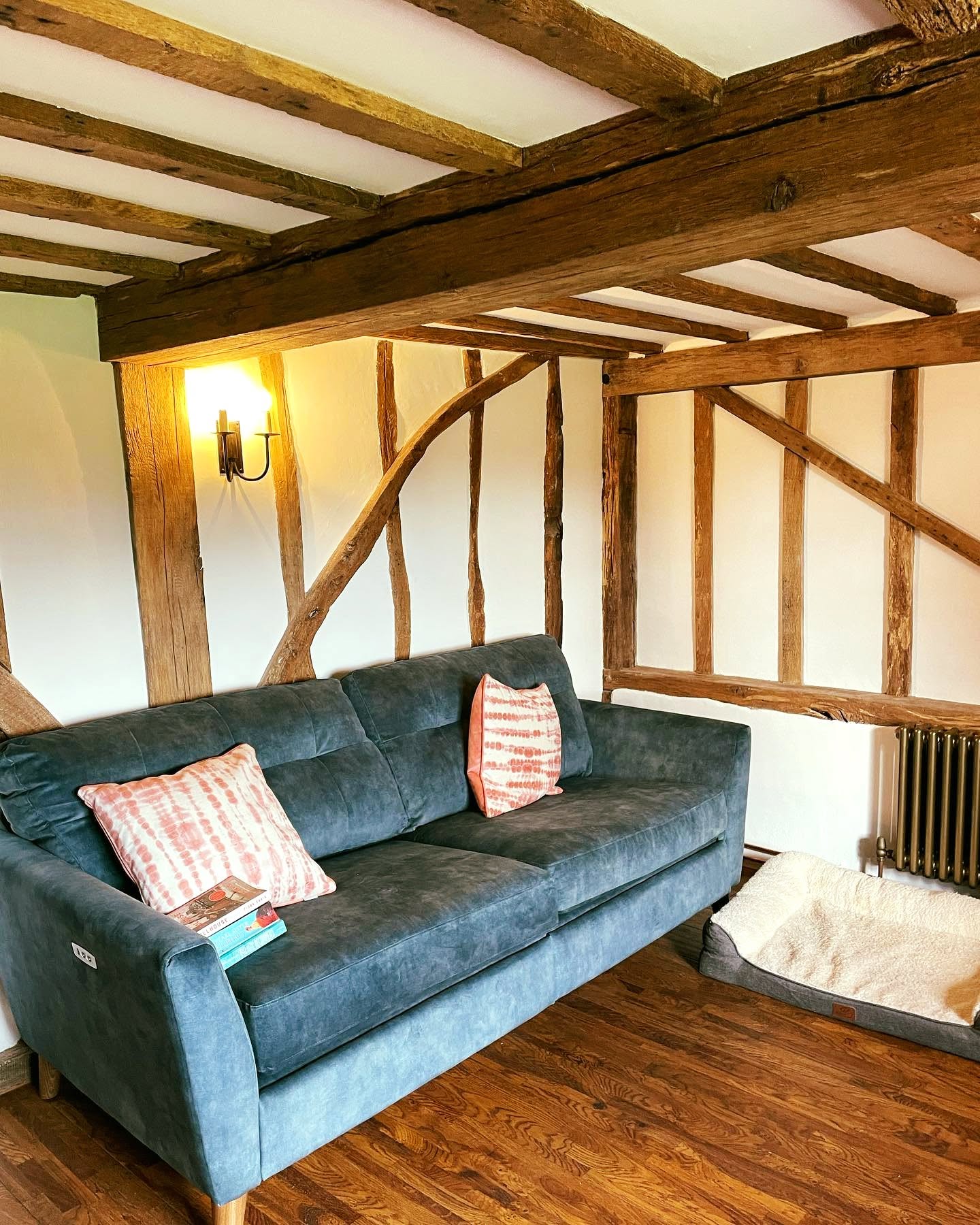 Cosy cottage living room with exposed beams and white FineLime plaster walls