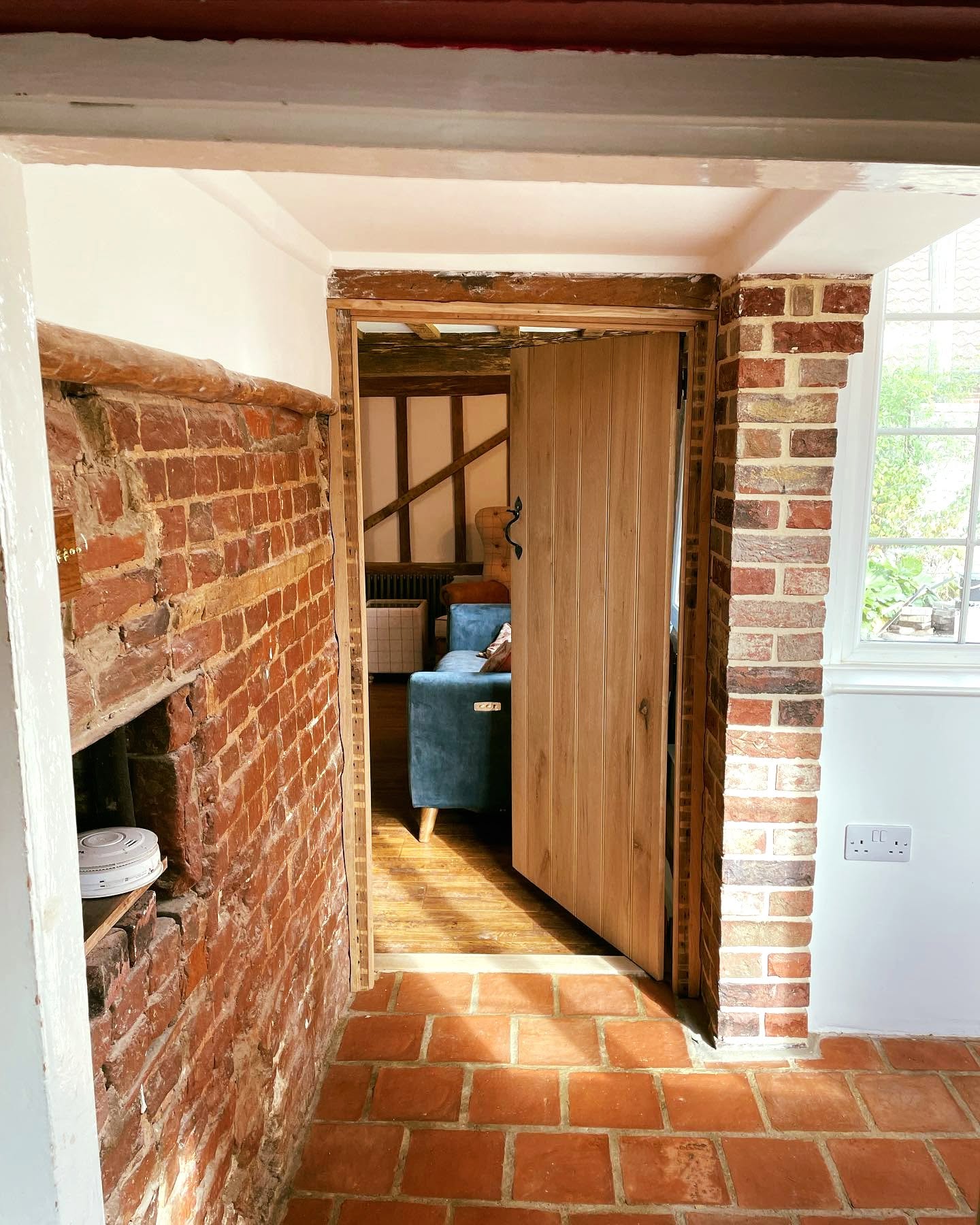 Cosy cottage living room with exposed beams and white FineLime plaster walls