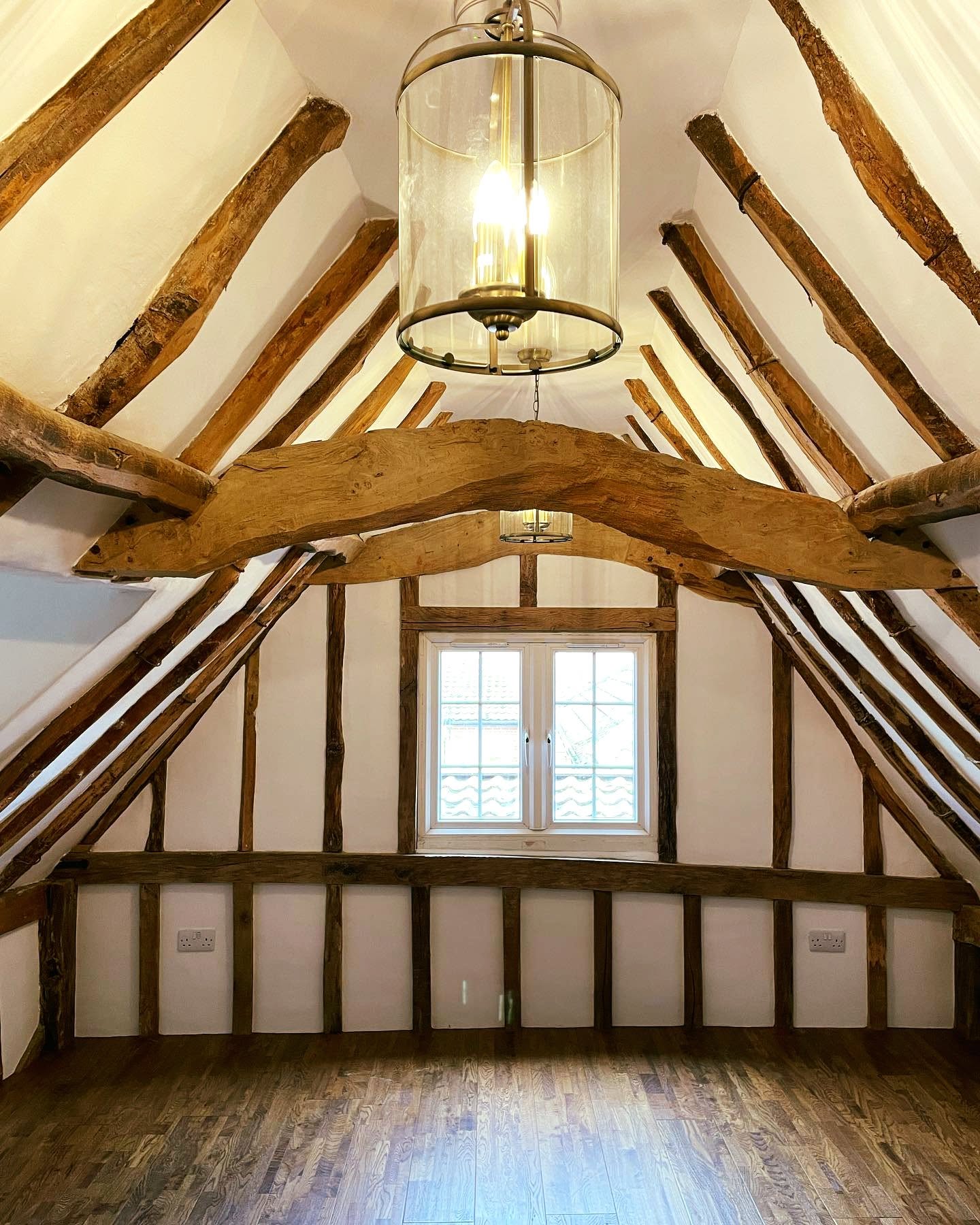 Cosy cottage living room with exposed beams and white FineLime plaster walls