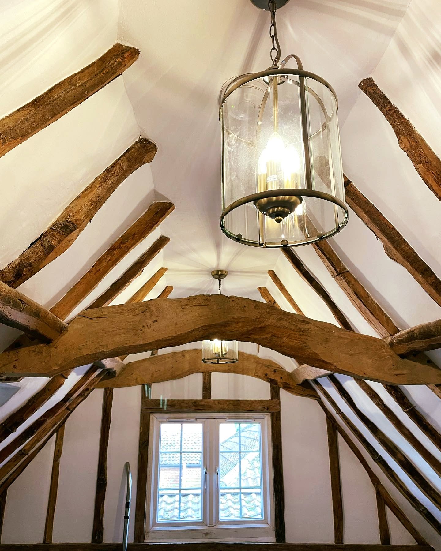 Cosy cottage living room with exposed beams and white FineLime plaster walls